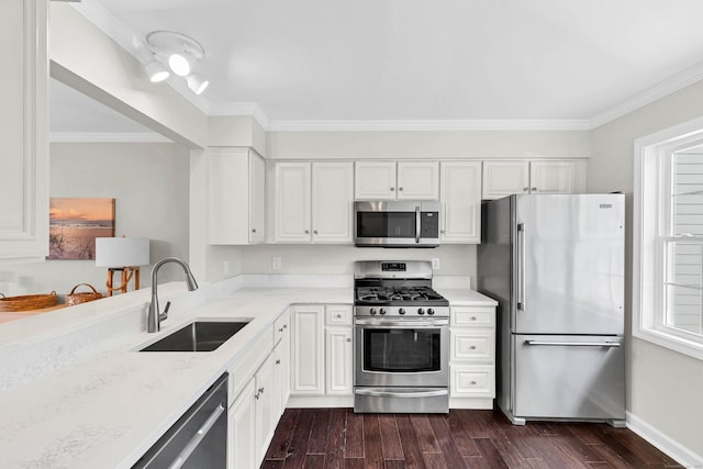 kitchen featuring stainless steel appliances, dark wood-style floors, a sink, white cabinetry, and ornamental molding
