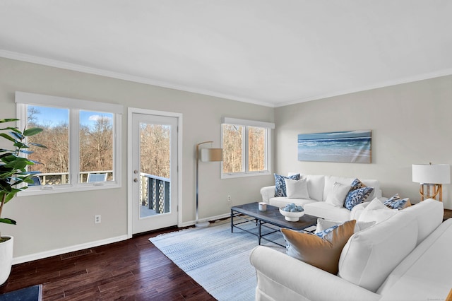 living room with crown molding, baseboards, and wood finished floors