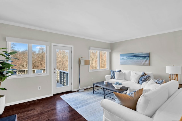 living area with baseboards, crown molding, wood finished floors, and visible vents