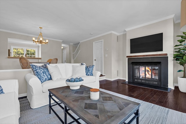 living area featuring baseboards, a lit fireplace, wood finished floors, and ornamental molding