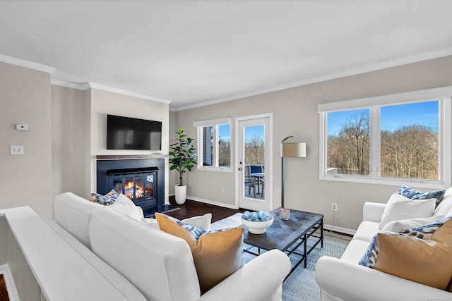 living room featuring a glass covered fireplace, crown molding, baseboards, and dark wood-style flooring