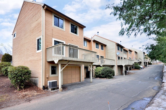 view of building exterior with a residential view, cooling unit, and a garage