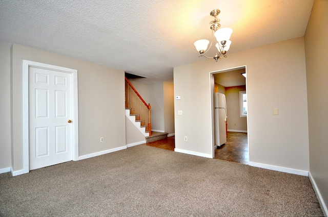 unfurnished room with stairway, dark carpet, a textured ceiling, and baseboards