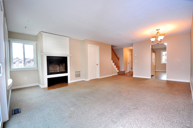 unfurnished living room with carpet flooring, a fireplace, stairs, and visible vents