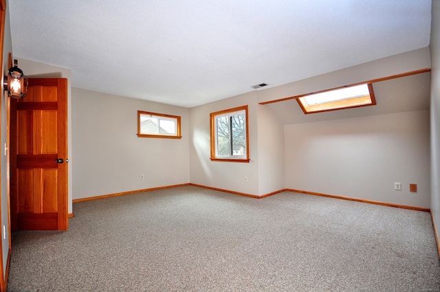 carpeted empty room featuring visible vents and baseboards