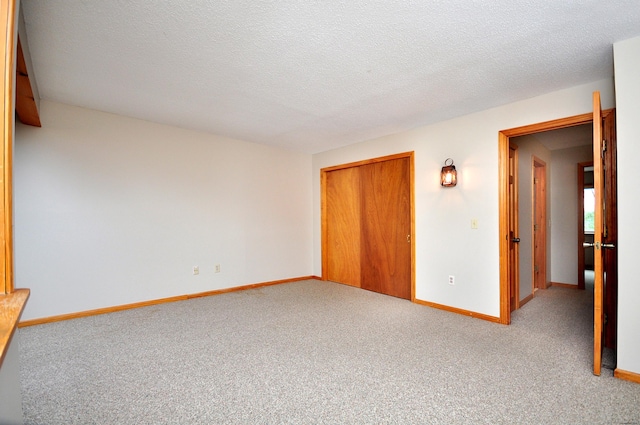 unfurnished bedroom featuring a closet, baseboards, a textured ceiling, and carpet flooring