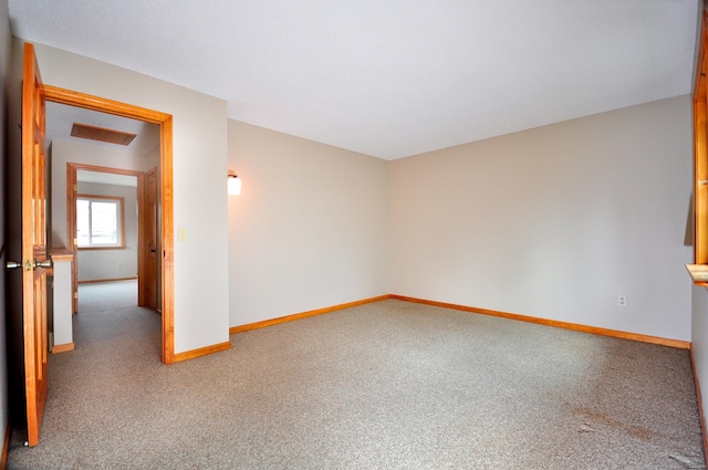 carpeted spare room featuring visible vents and baseboards