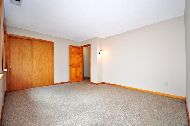 unfurnished bedroom with a closet, baseboards, and carpet flooring