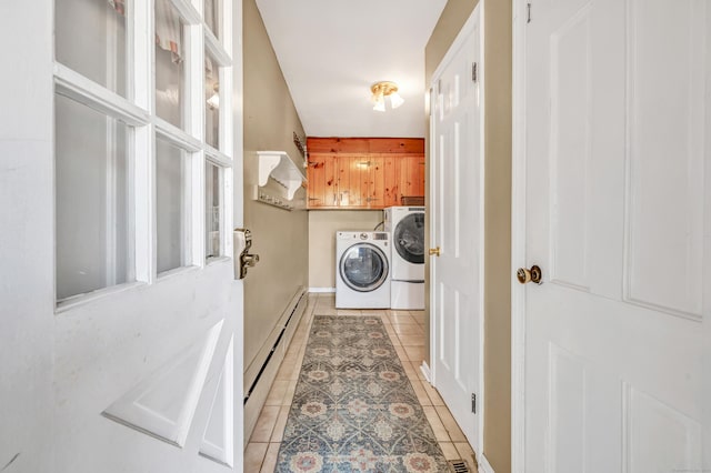 washroom with light tile patterned floors, a baseboard radiator, cabinet space, and washer and clothes dryer