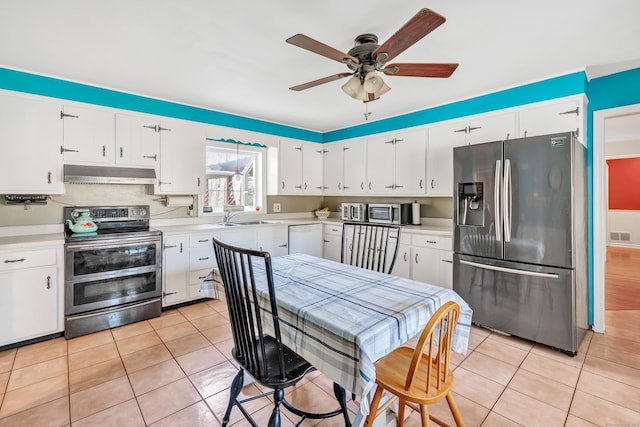 kitchen featuring under cabinet range hood, light tile patterned floors, stainless steel appliances, and a sink