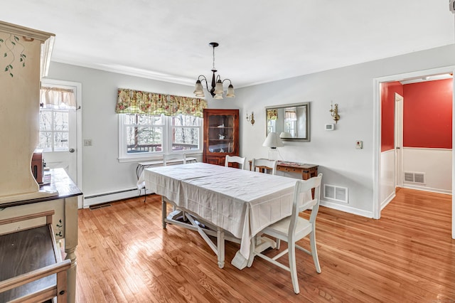 dining area featuring light wood-type flooring, visible vents, a wealth of natural light, and a baseboard radiator