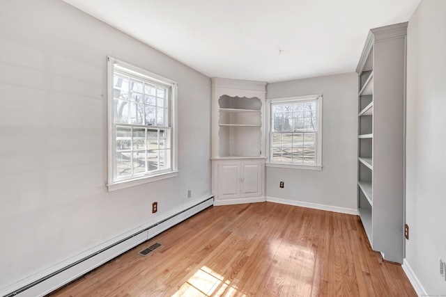 interior space featuring baseboards, light wood-type flooring, and a baseboard radiator