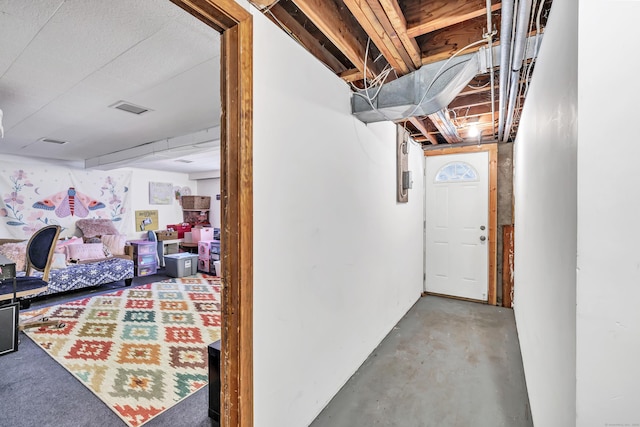 corridor with visible vents and unfinished concrete floors