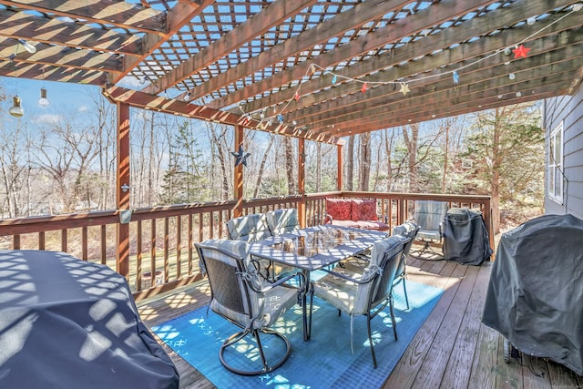 wooden deck with a grill, outdoor dining space, and a pergola