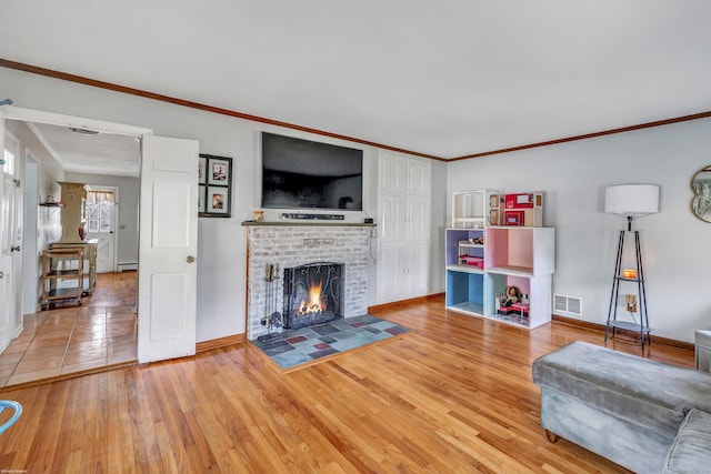 living area featuring light wood finished floors, visible vents, and ornamental molding