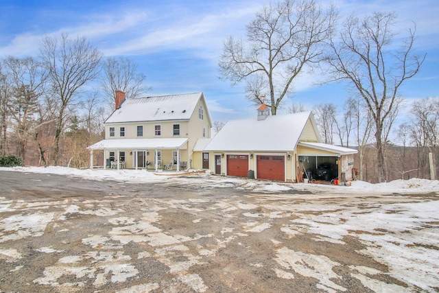 view of front of home featuring an attached garage, driveway, and a chimney