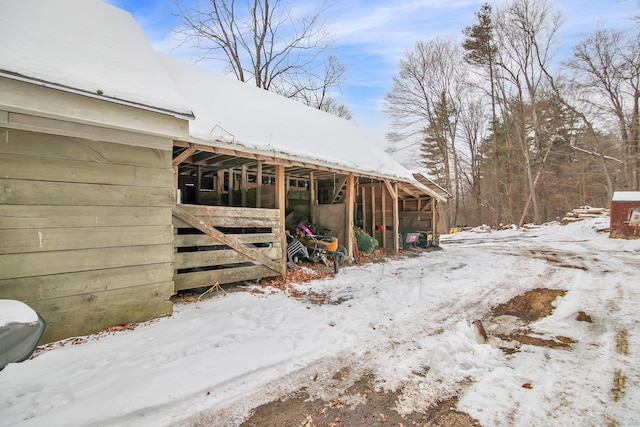 snow covered structure with an outbuilding and an exterior structure