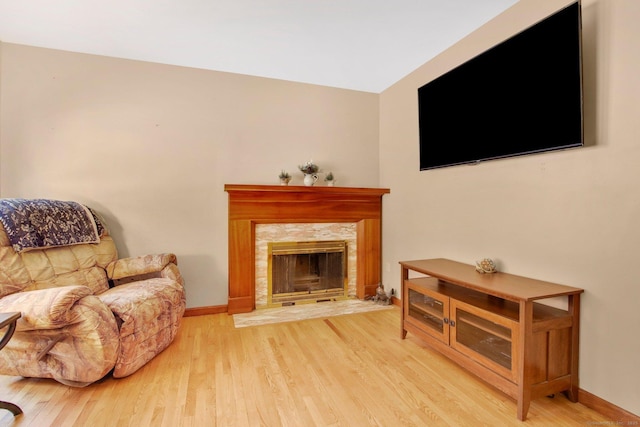 sitting room featuring wood finished floors, baseboards, and a premium fireplace