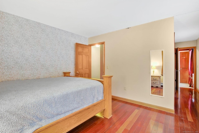 bedroom with baseboards and hardwood / wood-style flooring