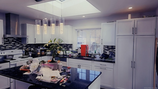kitchen with electric stove, a sink, white cabinetry, wall chimney range hood, and decorative backsplash