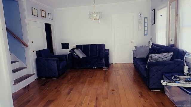 living area featuring a chandelier, hardwood / wood-style floors, stairs, and ornamental molding