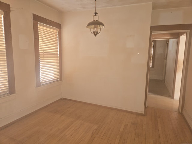 spare room featuring light wood-type flooring and baseboards