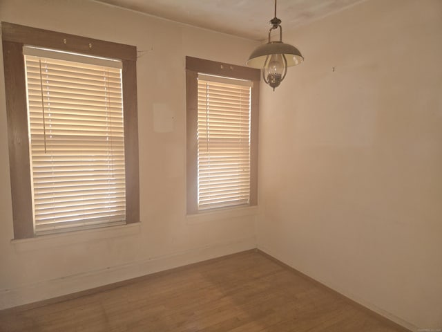 empty room with baseboards and wood finished floors