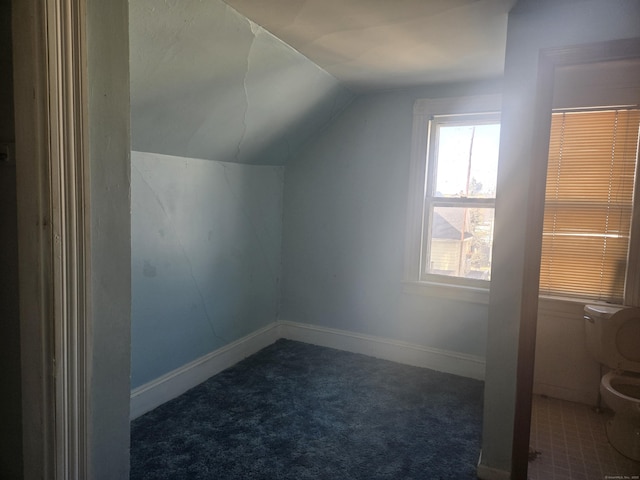 bonus room featuring lofted ceiling, carpet flooring, and baseboards