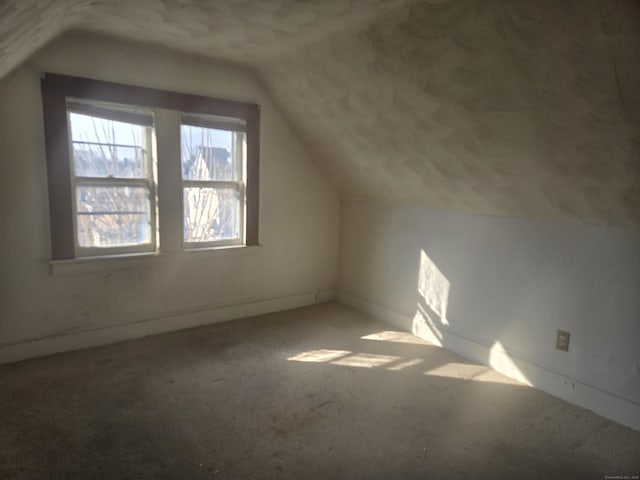 additional living space featuring lofted ceiling