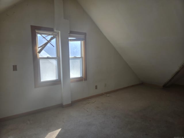 additional living space featuring lofted ceiling, baseboards, and carpet floors