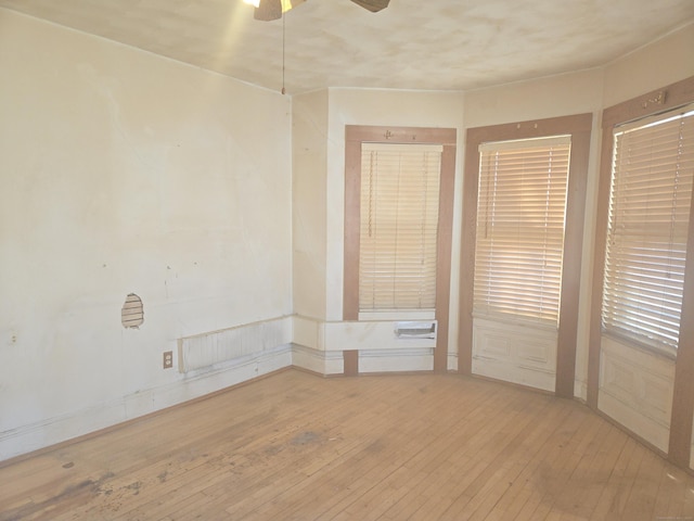 empty room with hardwood / wood-style flooring and a ceiling fan