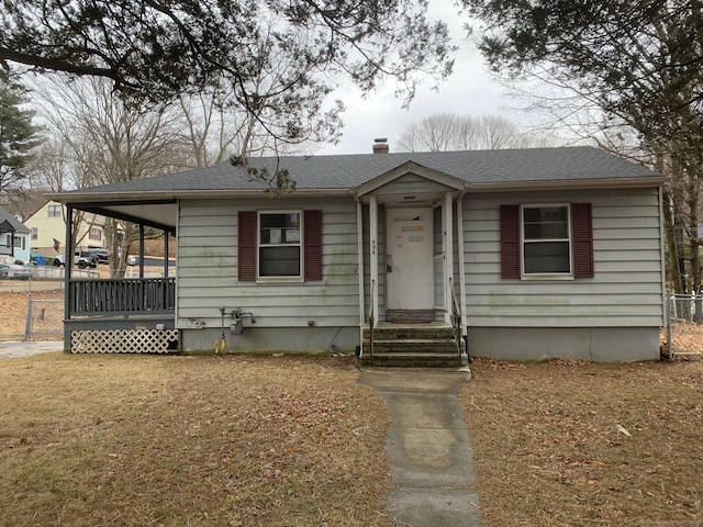 view of front facade with fence and roof with shingles