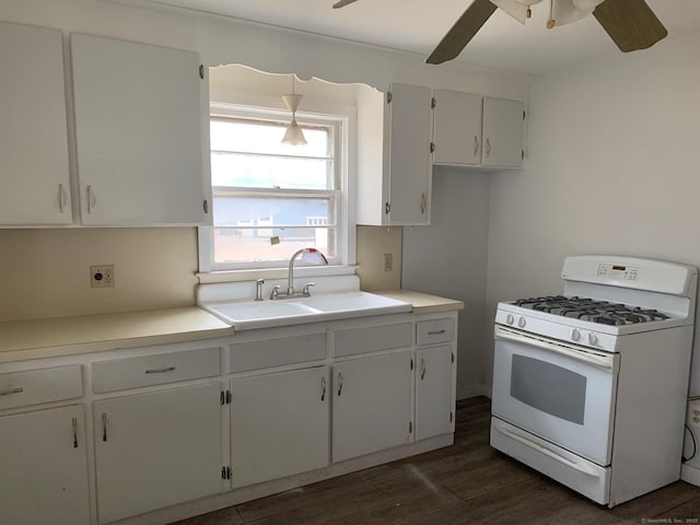 kitchen featuring a ceiling fan, a sink, dark wood finished floors, white gas range oven, and white cabinets