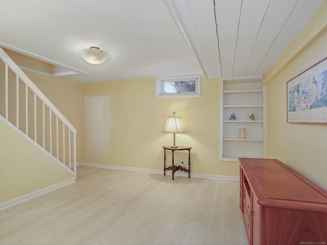 interior space with light wood finished floors, built in features, stairs, and baseboards