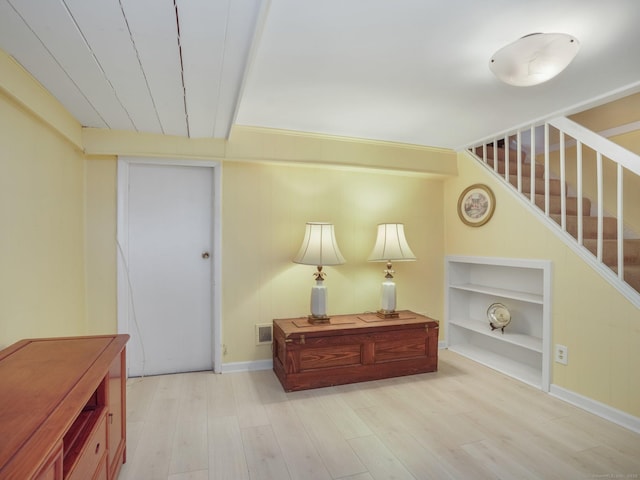 entrance foyer with visible vents, baseboards, wood finished floors, and stairs