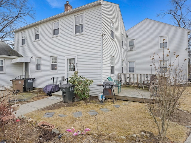 rear view of house with a chimney and a deck