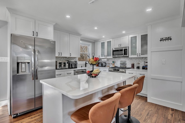 kitchen featuring appliances with stainless steel finishes, wood finished floors, and white cabinetry