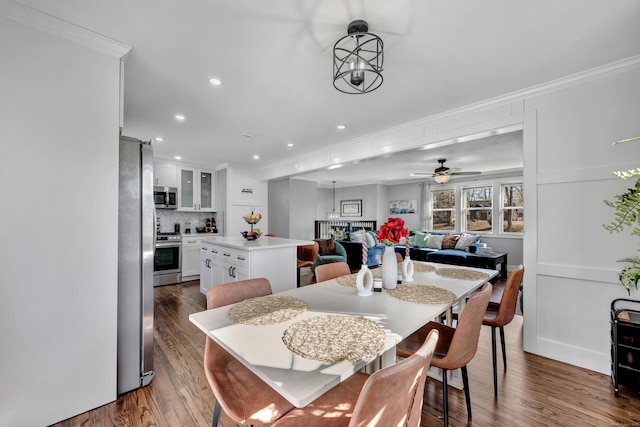 dining space with recessed lighting, ceiling fan with notable chandelier, crown molding, and dark wood-style flooring