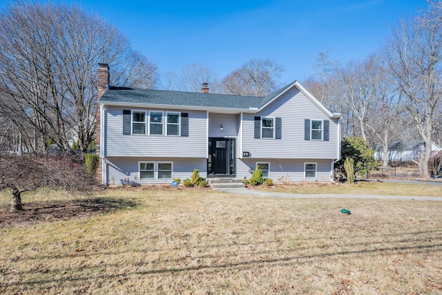 split foyer home featuring a chimney and a front yard