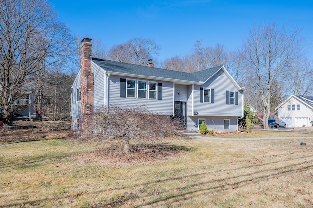 split foyer home featuring a chimney and a front lawn