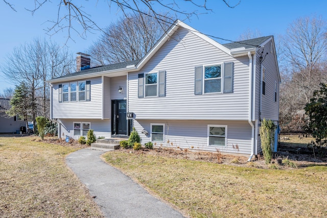 split foyer home with a front lawn and a chimney