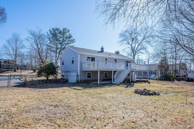 back of property with stairway, fence, a wooden deck, a yard, and a garage