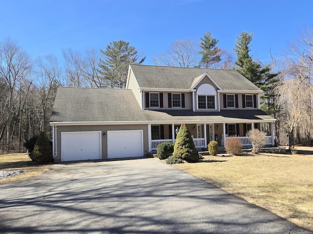 view of front of home featuring covered porch, an attached garage, a shingled roof, and driveway