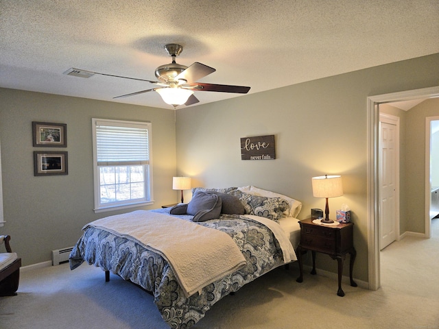 carpeted bedroom with a baseboard radiator, baseboards, a textured ceiling, and visible vents