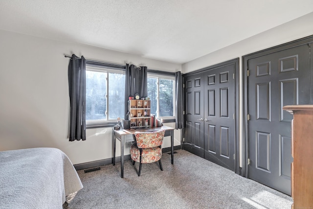 carpeted bedroom with baseboards, visible vents, a closet, and a textured ceiling