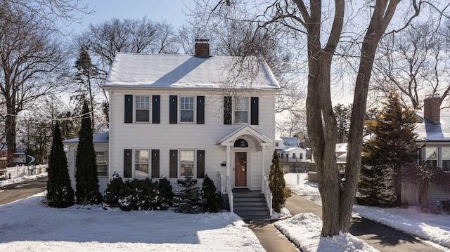 view of front of house featuring a chimney and fence