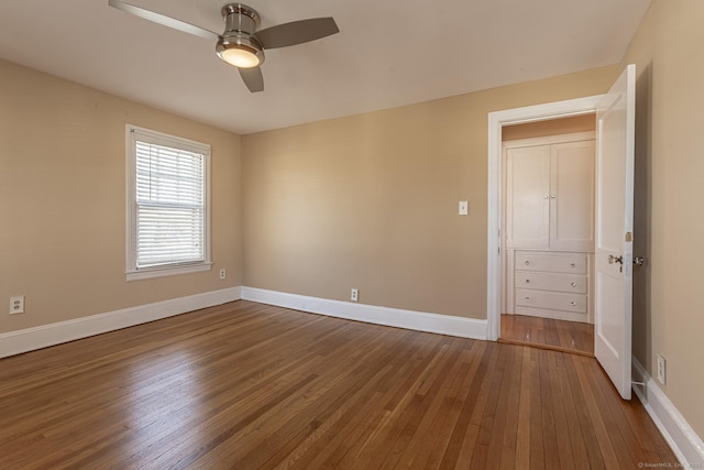 unfurnished bedroom with baseboards, wood-type flooring, and a ceiling fan