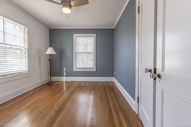 unfurnished room featuring a ceiling fan, crown molding, baseboards, and hardwood / wood-style flooring