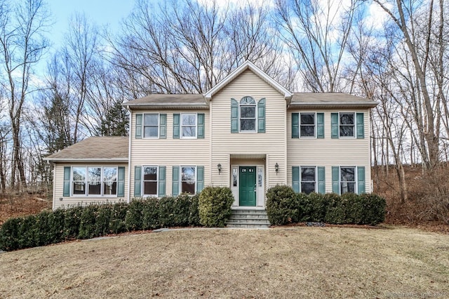 colonial inspired home featuring a front lawn