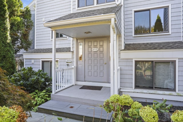 property entrance featuring roof with shingles